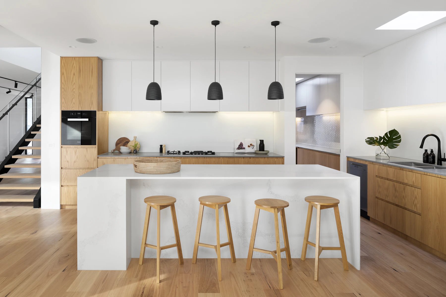 Modern renovated kitchen with wood cabinetry and a stone island